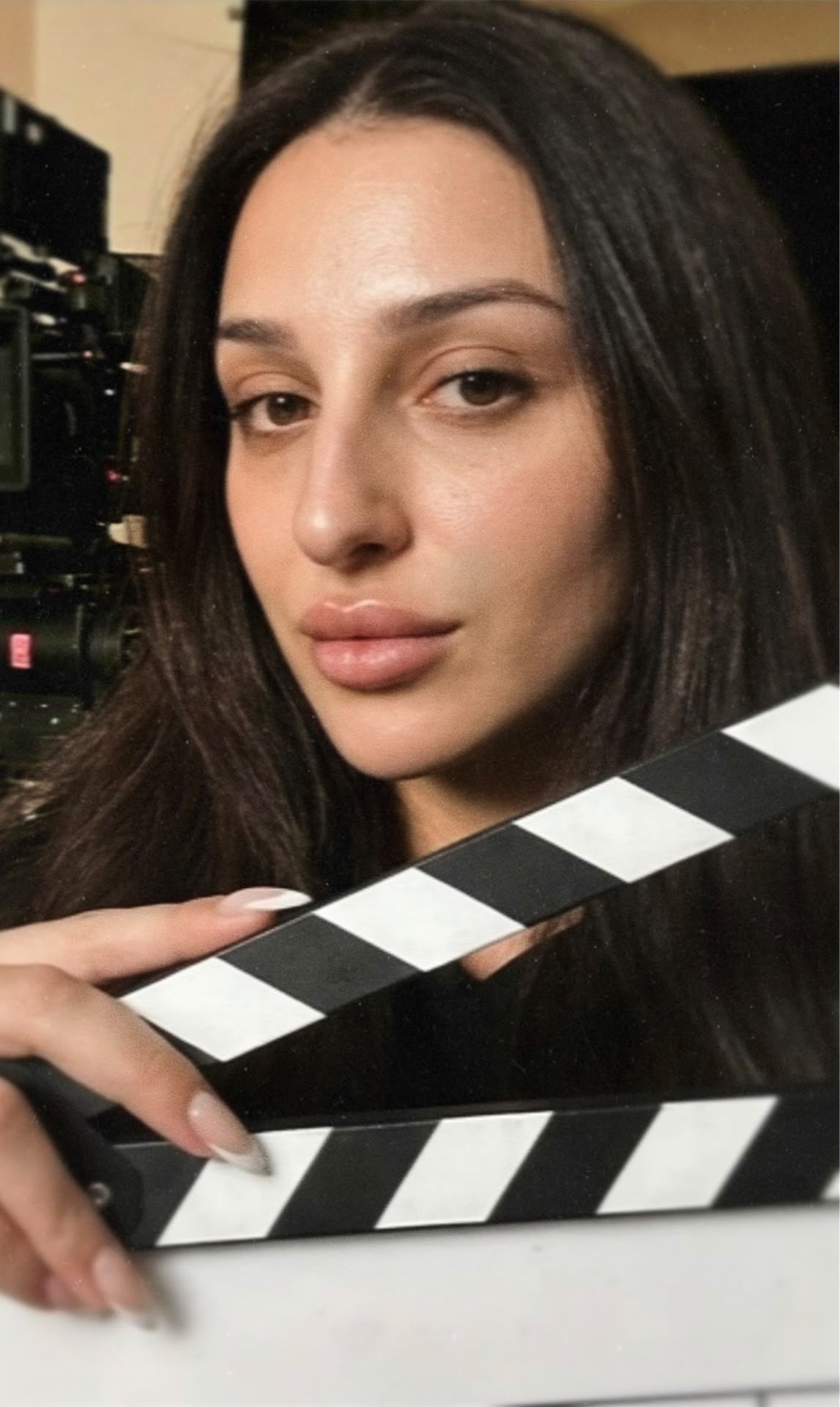 Aylin Baykal, writer and cast member of the upcoming horror feature Baby Girl, holds a clapperboard on set.