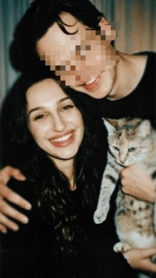Aylin Baykal smiling while holding a tabby cat beside a man whose face is obscured in an October 2019 personal photo.