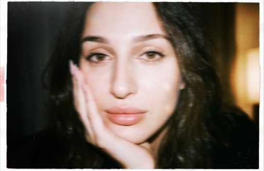 Close-up portrait of Aylin Baykal looking at the camera and winking.