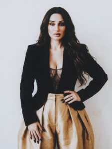Aylin Baykal standing in a fitted black blazer and dramatic gold trousers for Starchuska Women’s AW’26.