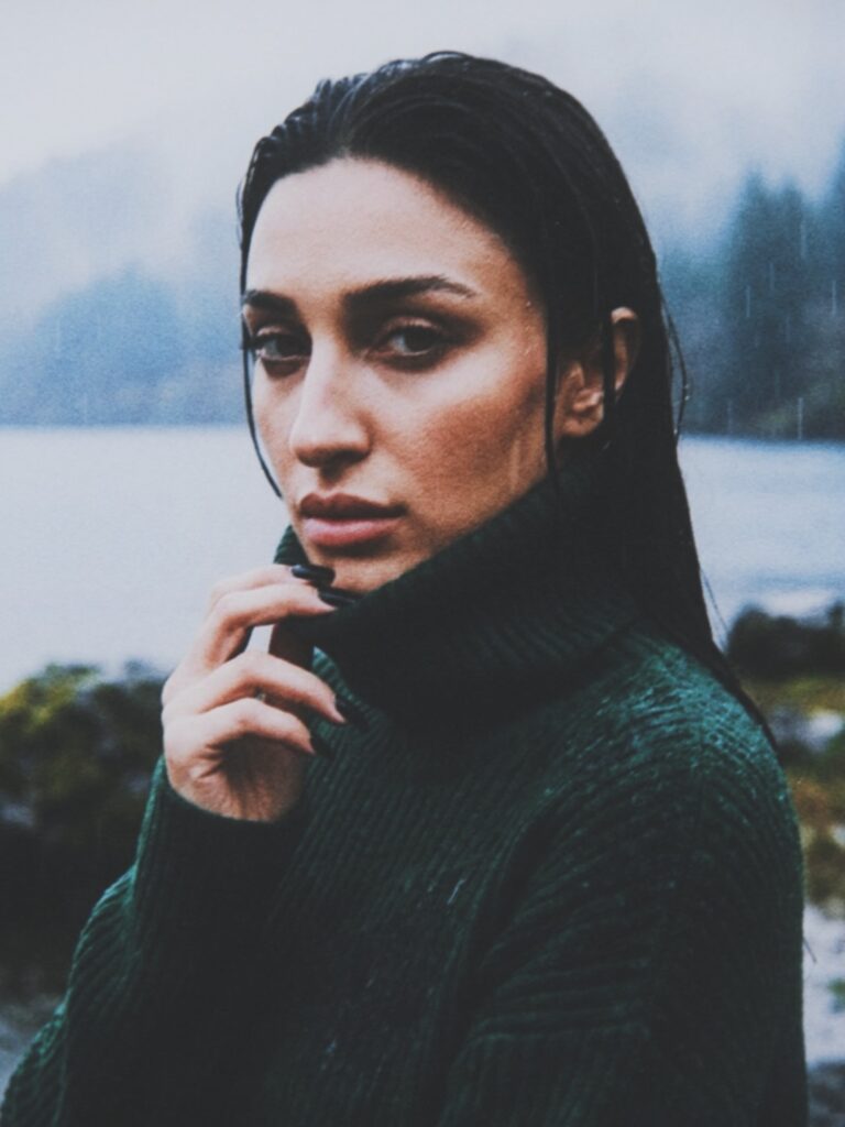 Close-up portrait of Aylin Baykal with wet hair wearing a dark green high-neck coat for Starchuska Women’s AW’26.